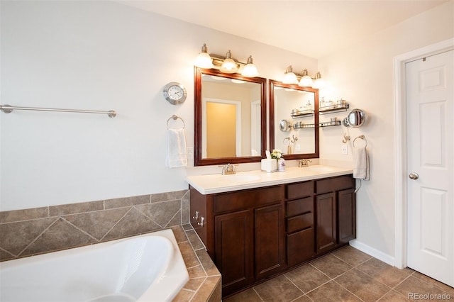 full bath featuring tiled bath, double vanity, a sink, and tile patterned floors