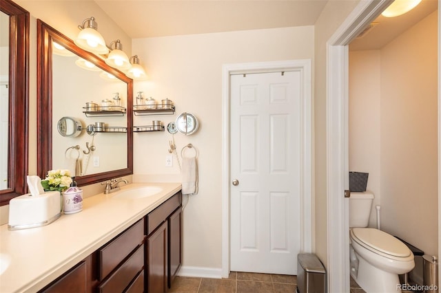 full bathroom featuring toilet, tile patterned floors, baseboards, and vanity