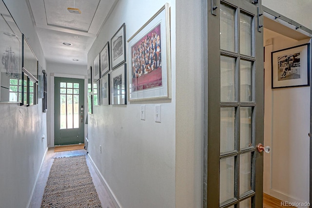 corridor featuring a barn door and wood-type flooring