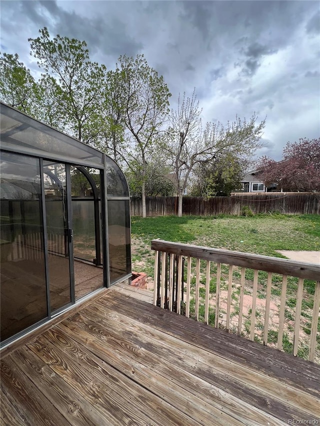 wooden deck featuring a lawn