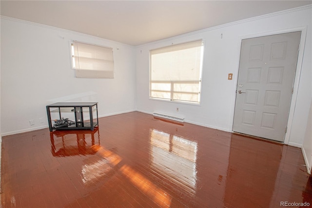 empty room featuring crown molding, wood-type flooring, and baseboard heating