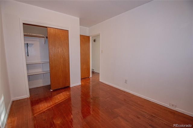 unfurnished bedroom with hardwood / wood-style floors and a closet