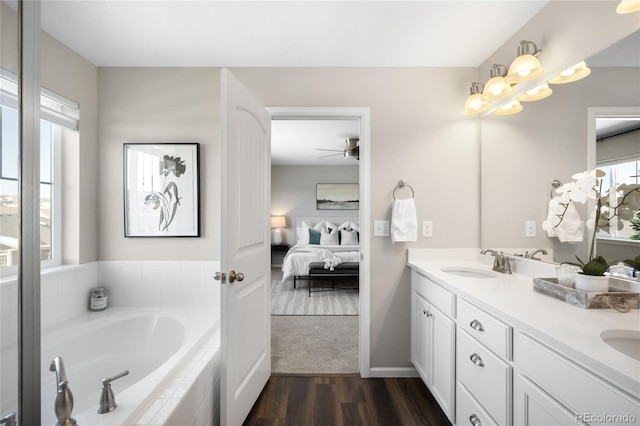 bathroom featuring vanity, tiled bath, and hardwood / wood-style floors