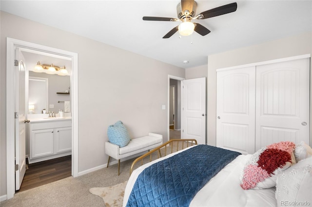 carpeted bedroom with ensuite bathroom, sink, ceiling fan, and a closet