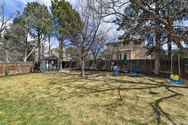 view of yard with an outdoor structure, a shed, and a fenced backyard