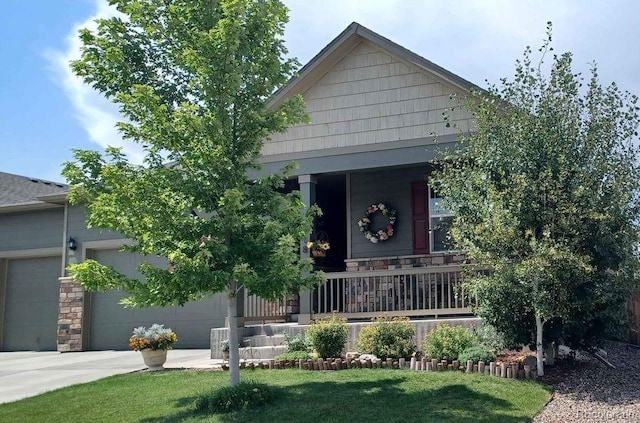 view of front facade featuring a front yard, a garage, and covered porch