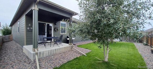 back of property featuring a patio and a yard