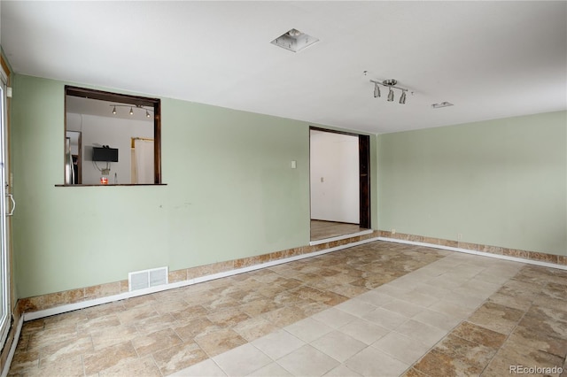 unfurnished room with visible vents and baseboards