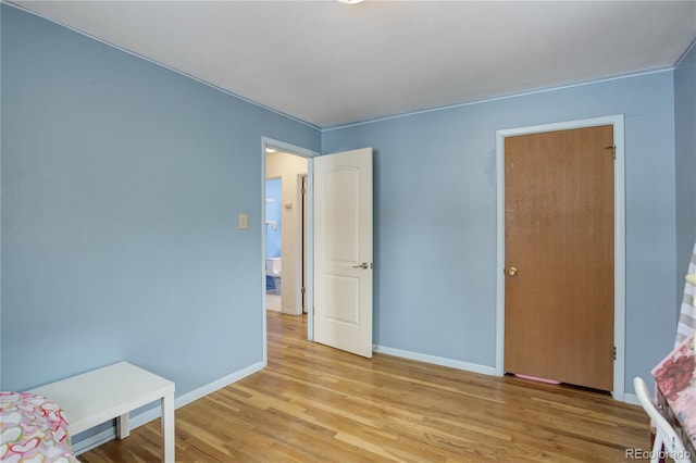 bedroom featuring light wood-style floors and baseboards