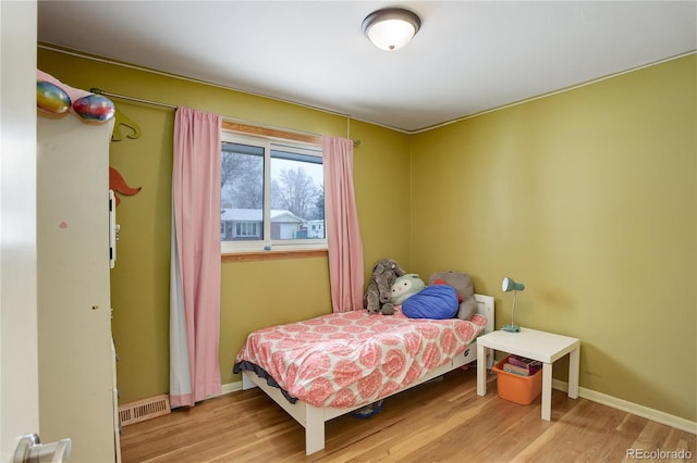 bedroom featuring light wood-type flooring, visible vents, and baseboards