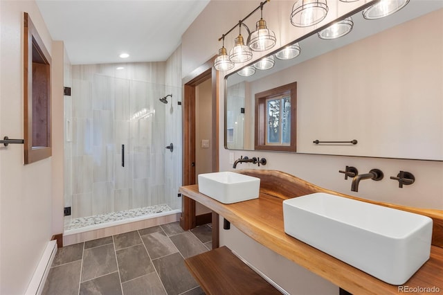 full bath with a baseboard radiator, a tile shower, and a sink