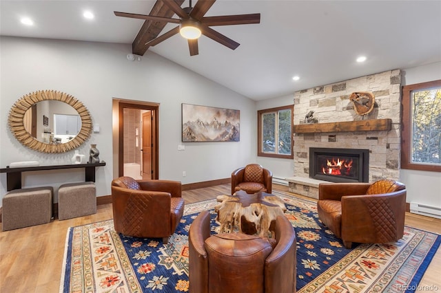 living area with vaulted ceiling with beams, a stone fireplace, and wood finished floors