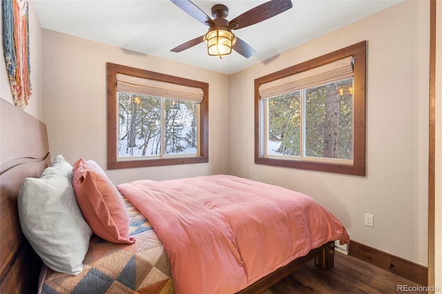 bedroom with a ceiling fan, baseboards, and wood finished floors