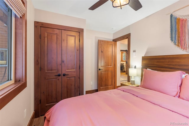 bedroom with washer / dryer, a closet, baseboards, and a ceiling fan