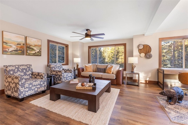 living area with wood finished floors, a ceiling fan, and baseboards