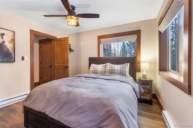 bedroom featuring a baseboard radiator, wood finished floors, and baseboards