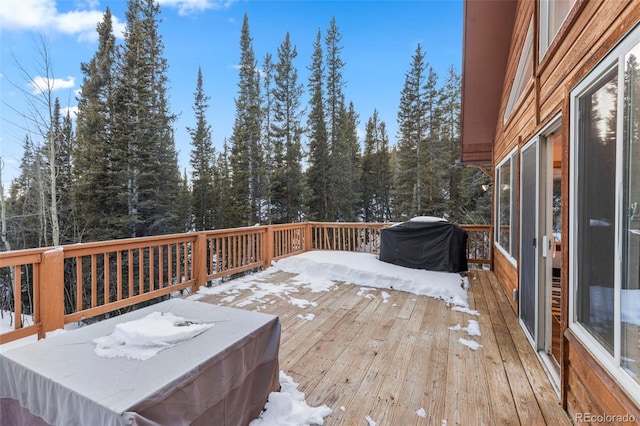 snow covered deck with a grill