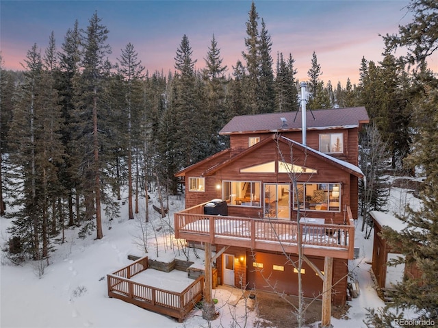 snow covered property with a deck