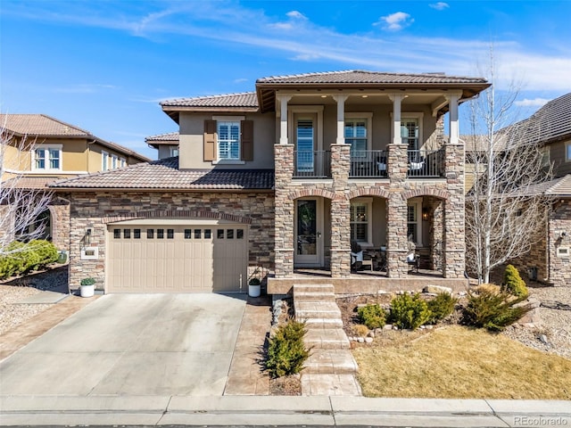 view of front of home with a tile roof, driveway, a balcony, and stucco siding