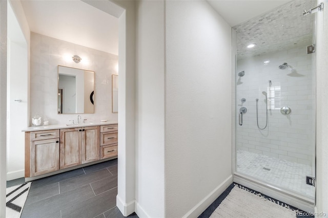 full bath with a shower stall, baseboards, and vanity