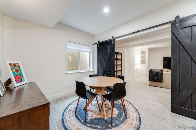 dining room with a barn door, built in shelves, recessed lighting, carpet floors, and baseboards