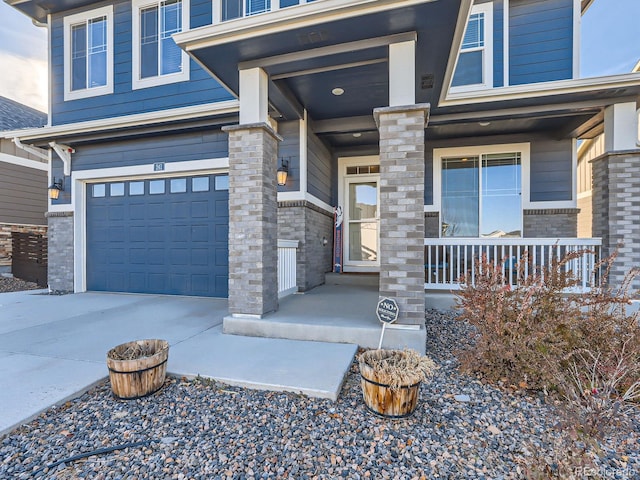 view of exterior entry with a porch and a garage