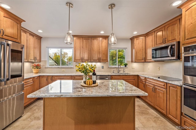 kitchen featuring a wealth of natural light, a center island, decorative light fixtures, and appliances with stainless steel finishes