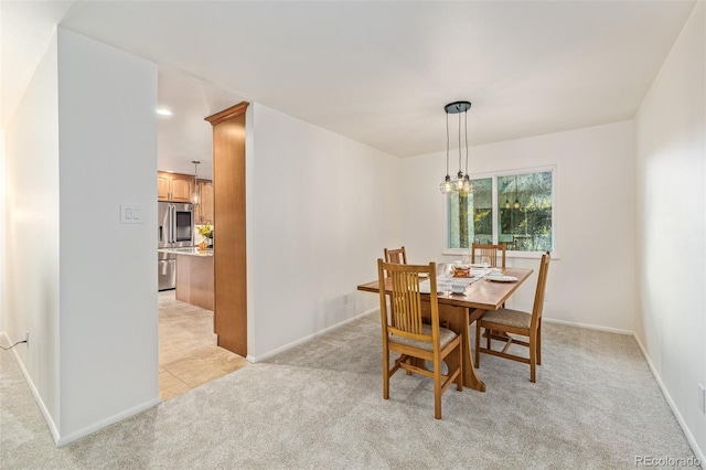 carpeted dining area with a chandelier