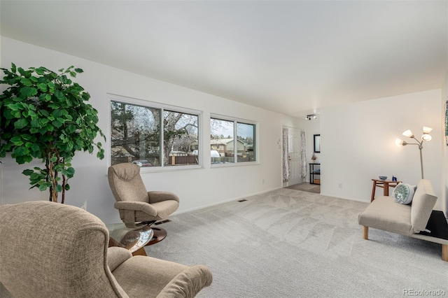 sitting room featuring an inviting chandelier and light colored carpet