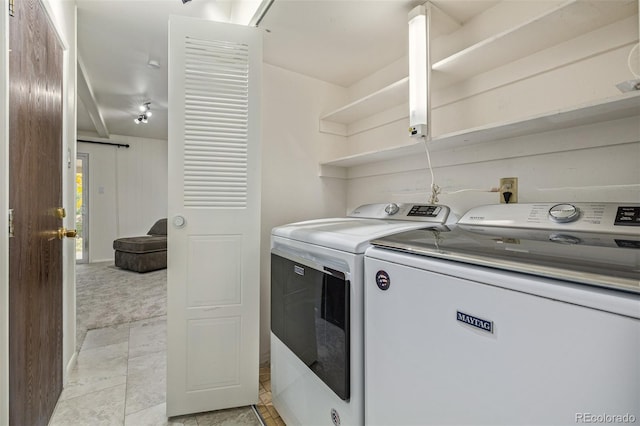 laundry area with light tile patterned floors and washer and clothes dryer