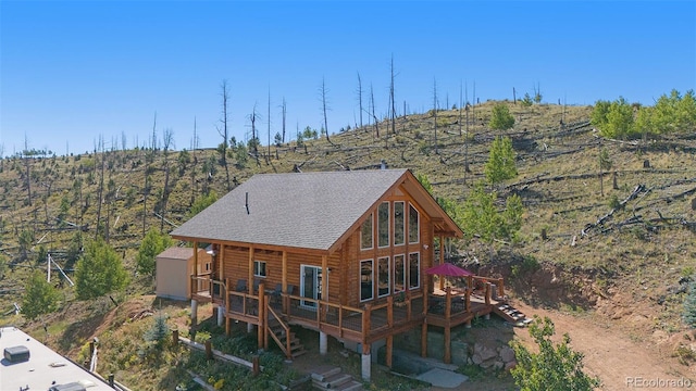 14077 S State Highway 67, Woodland Park, CO 80863 - back of property with a deck, log exterior, and a shingled roof