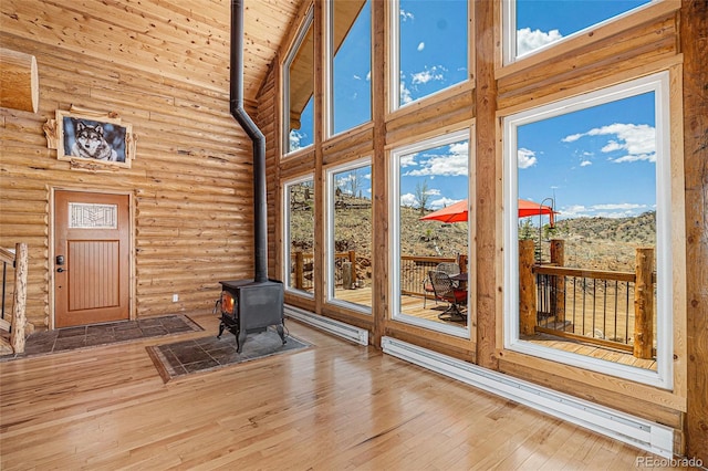 14077 S State Highway 67, Woodland Park, CO 80863 - unfurnished sunroom with baseboard heating, a wood stove, plenty of natural light, and lofted ceiling