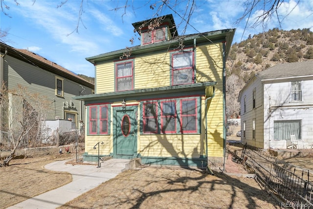 rear view of property featuring entry steps and fence