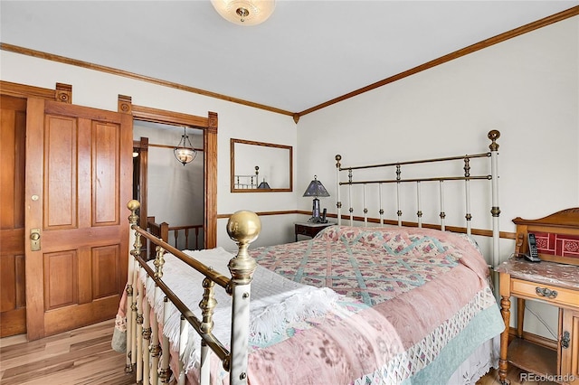 bedroom featuring light wood-type flooring and crown molding