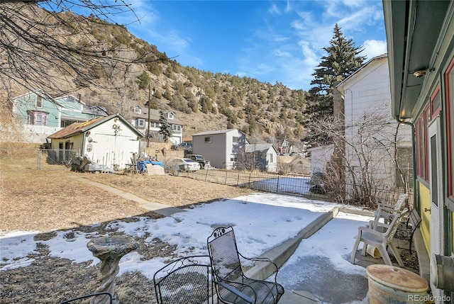 yard covered in snow with an outbuilding, a shed, and fence