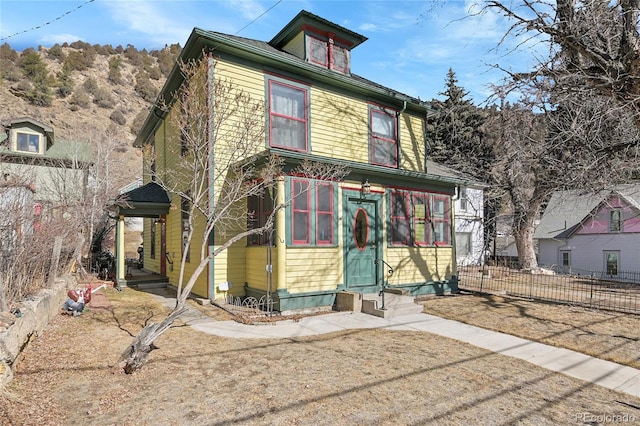 american foursquare style home with entry steps and fence