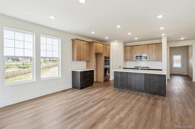 6384 E 154th Pl, Thornton, CO 80602 - kitchen featuring appliances with stainless steel finishes, light countertops, plenty of natural light, decorative backsplash, and recessed lighting