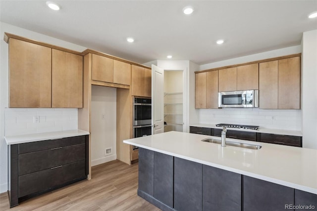 6384 E 154th Pl, Thornton, CO 80602 - kitchen with appliances with stainless steel finishes, a sink, light wood finished floors, tasteful backsplash, and recessed lighting