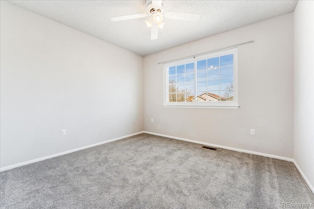 carpeted empty room with a ceiling fan, a textured ceiling, visible vents, and baseboards
