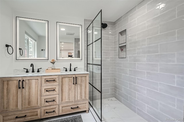 bathroom featuring a tile shower and vanity