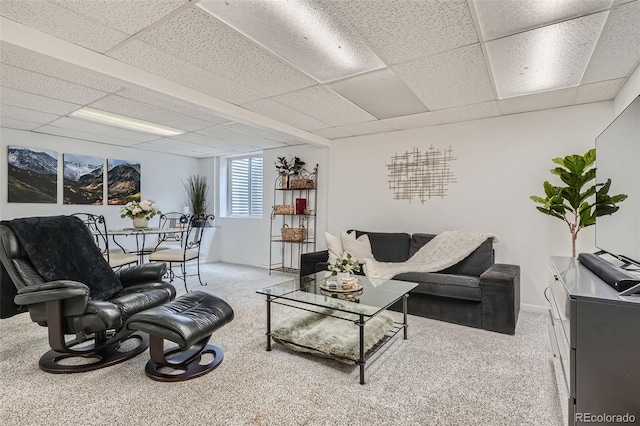 living room featuring a paneled ceiling and carpet