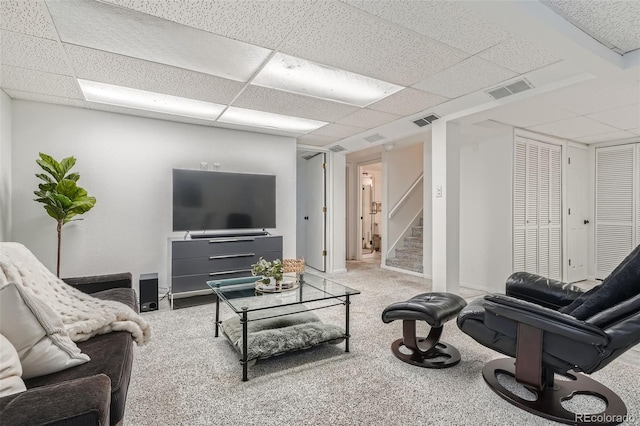 carpeted living room with a paneled ceiling