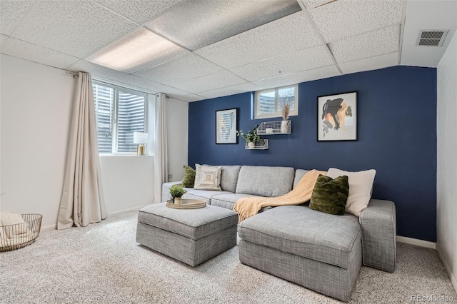 carpeted living room featuring a paneled ceiling