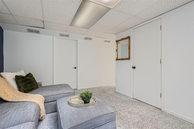 interior space featuring a paneled ceiling and light carpet