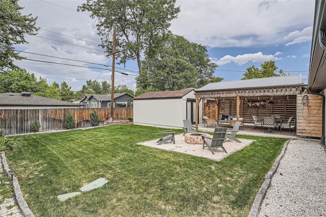 view of yard with a storage shed, an outdoor fire pit, and a patio