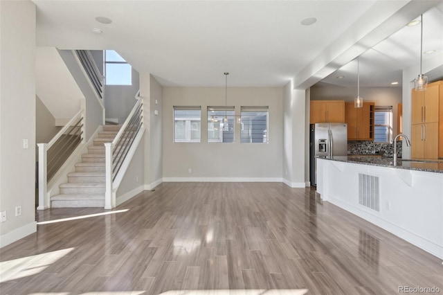 unfurnished living room featuring sink and hardwood / wood-style floors