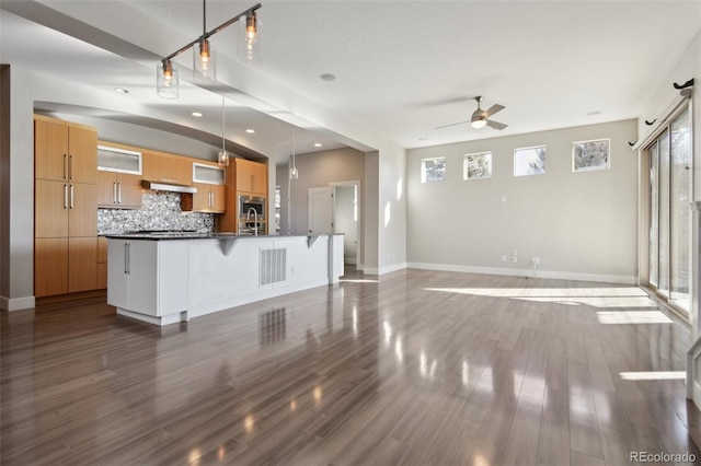 kitchen with decorative light fixtures, dark wood-type flooring, decorative backsplash, and ceiling fan