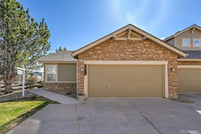 7511 S Sicily Way, Aurora, CO 80016 - view of front of home featuring stone siding, driveway, an attached garage, and a shingled roof