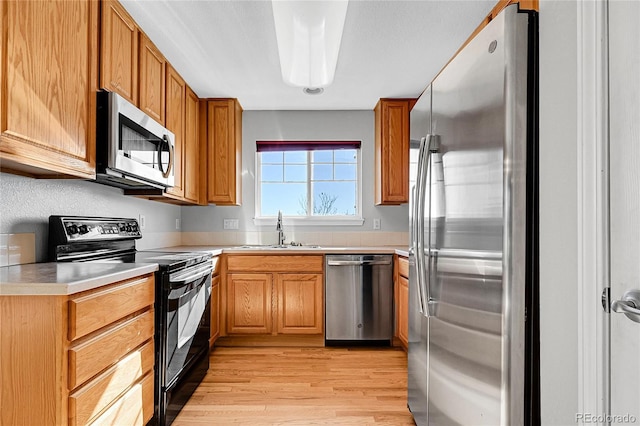 7511 S Sicily Way, Aurora, CO 80016 - kitchen featuring stainless steel appliances, a sink, light wood-style floors, light countertops, and brown cabinets