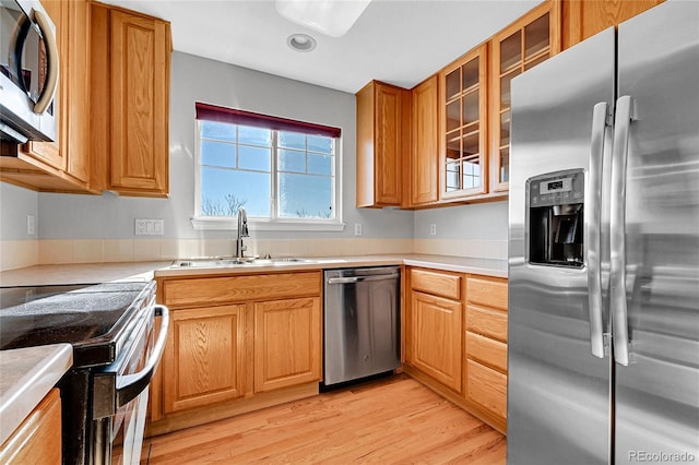 7511 S Sicily Way, Aurora, CO 80016 - kitchen with appliances with stainless steel finishes, a sink, light wood-style floors, and light countertops